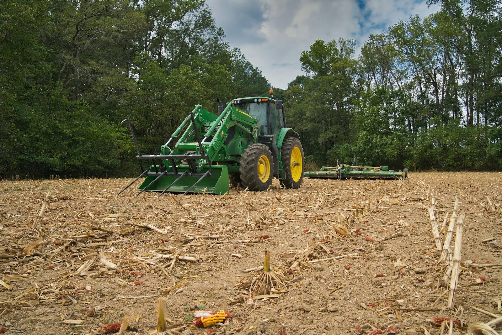 green harvester on brown soil